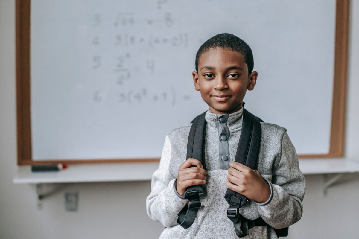 enfant avec livre de math et tableau blanc