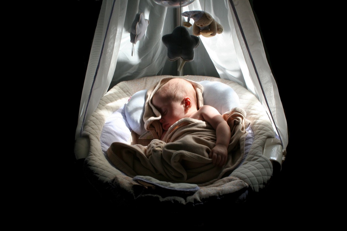 Um bebê dormindo tranquilamente em um berço seguro.