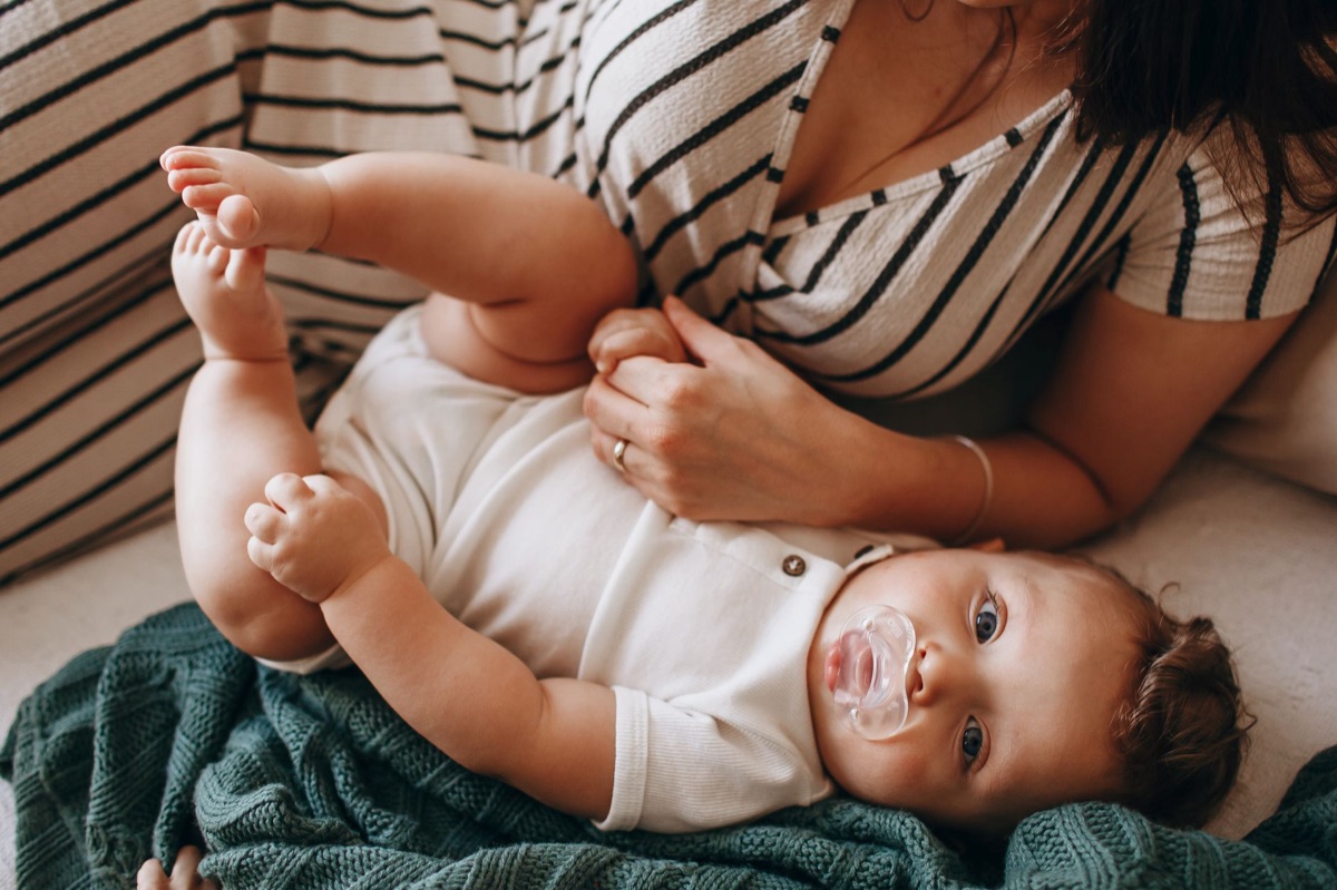 Bébé avec biberon et jouet sur le lit