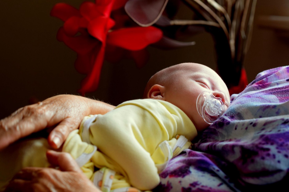 bambino che dorme con un biberon e un peluche