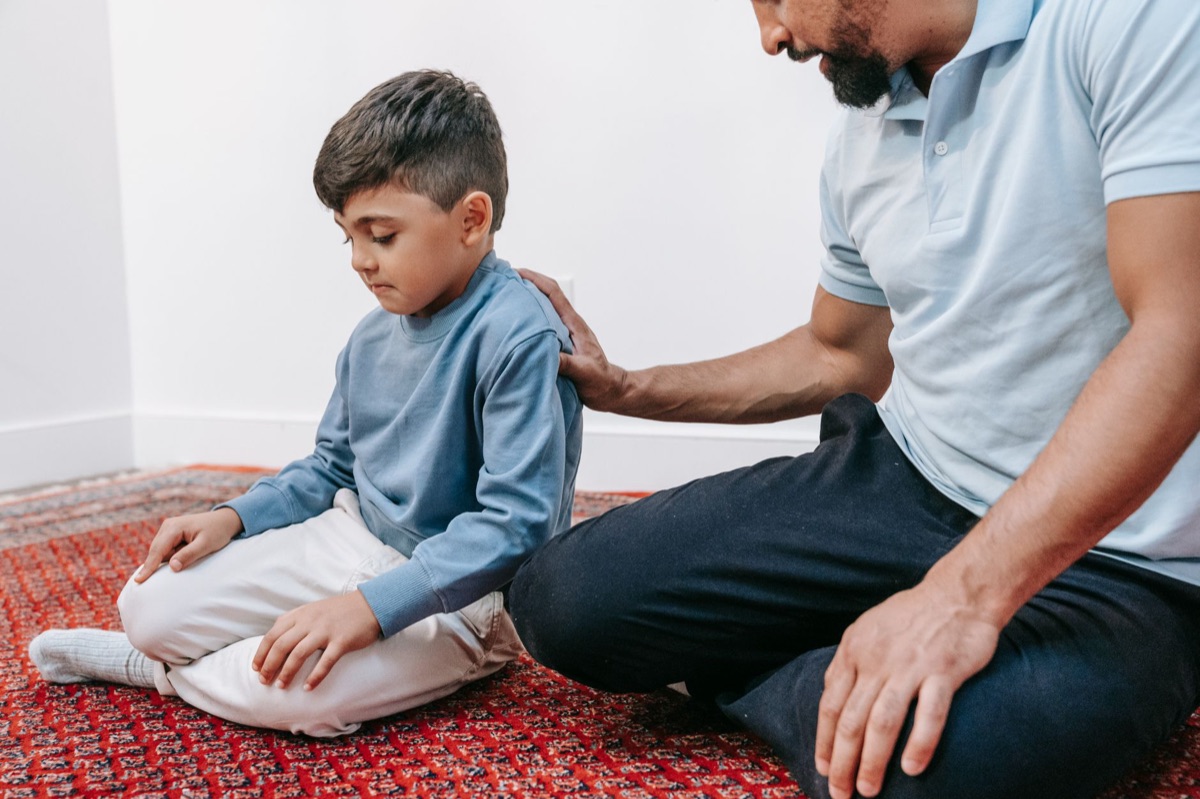 Un parent et un enfant assis calmement sur le sol après une crise de colère.