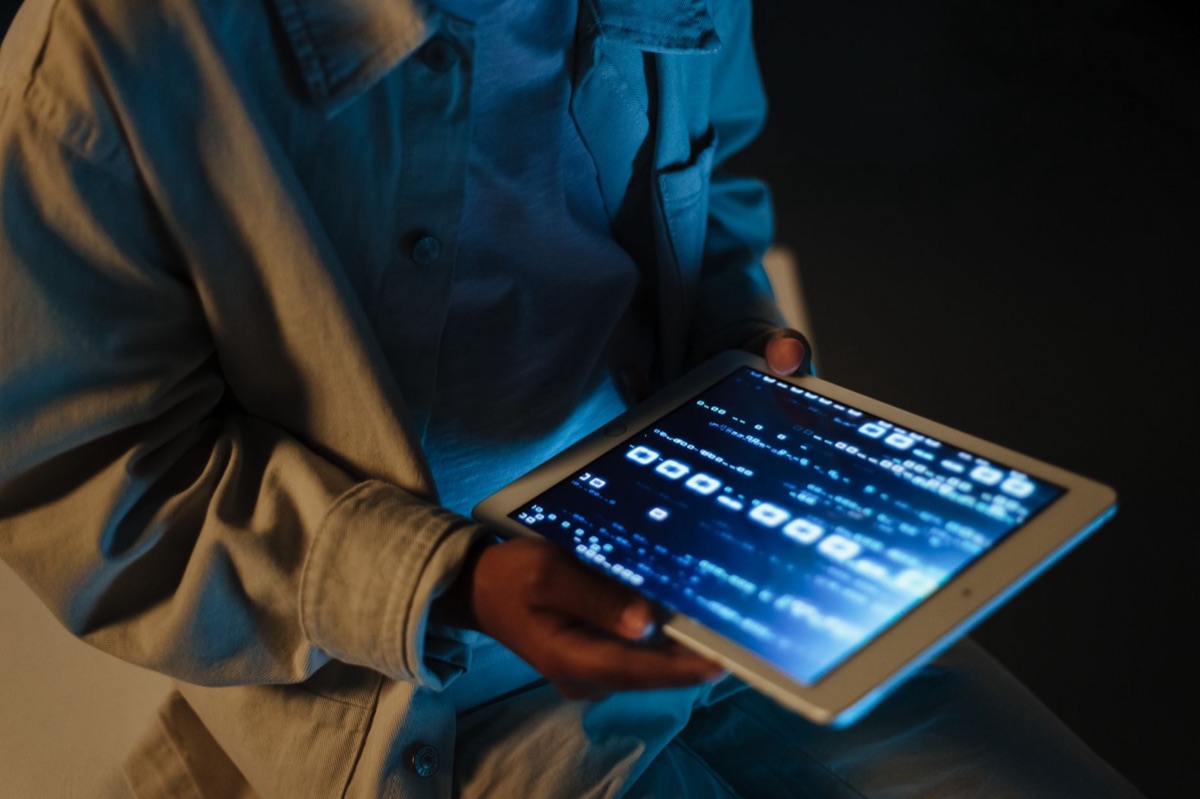 Child's hands interacting with a glowing tablet