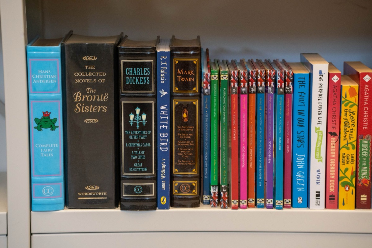 Stack of children's books on a wooden shelf